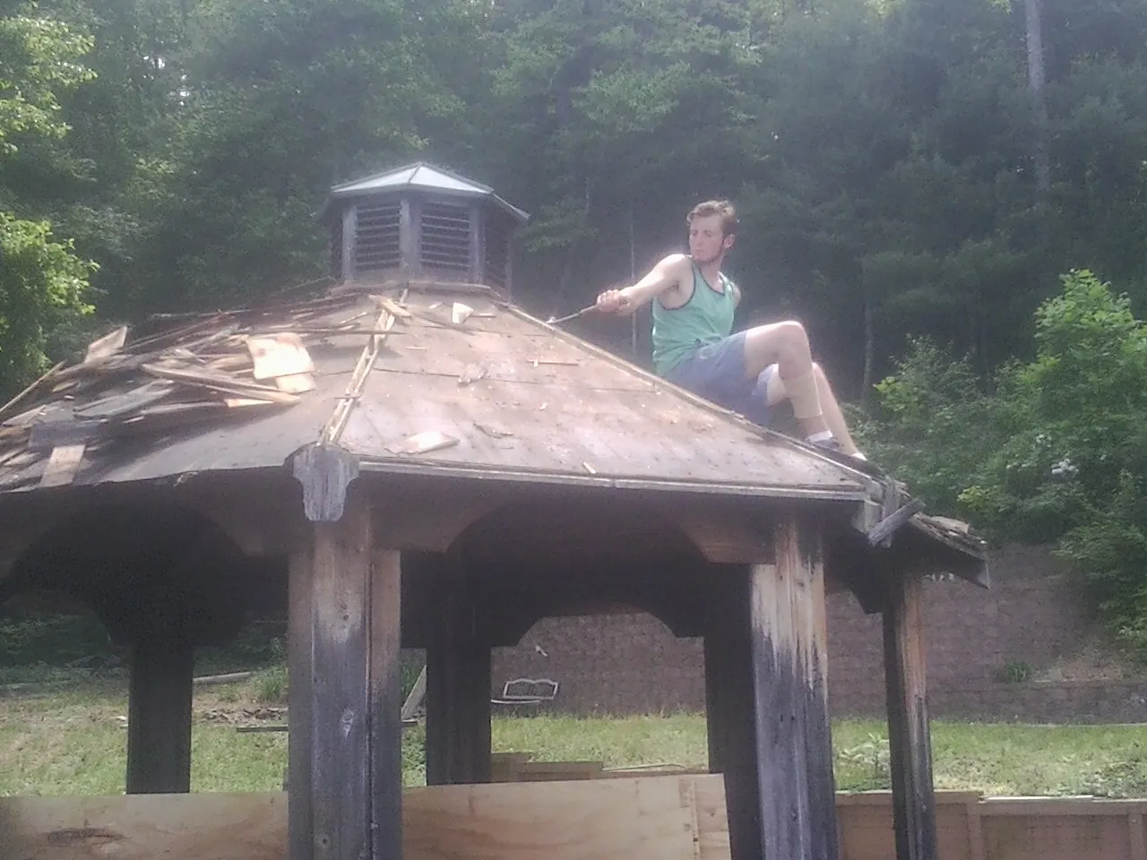 Tearing the old roof off a wooden gazebo before new shakes in North Sutton