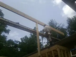 Carpenter setting a ridge beam over a new addition frame — Ice Dam Removal by Roofing Brothers in North Sutton