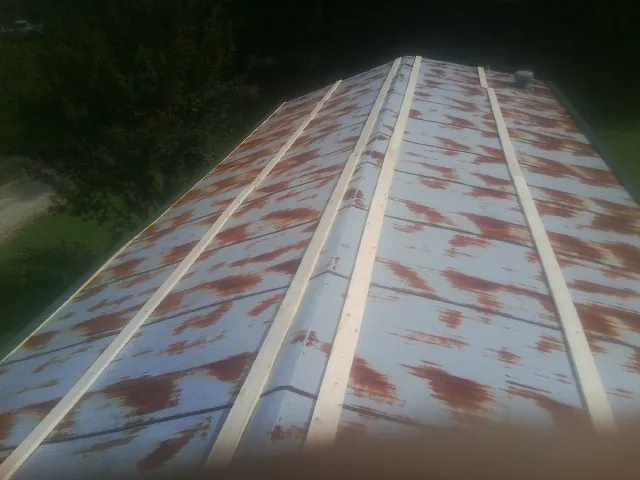 Rusted metal roof panels with new wood purlins before replacement — Storm Damage Roof Repair in North Sutton by Roofing Brothers